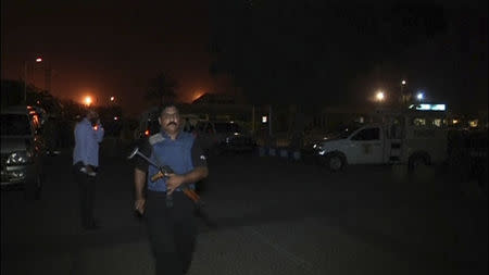 A police commando runs outside the old airport building at Jinnah International Airport in Karachi June 9, 2014 in this still image taken from video. Gunmen attacked one of Pakistan's biggest airports in Karachi on Sunday, killing at least five people, police said. REUTERS/Reuters TV