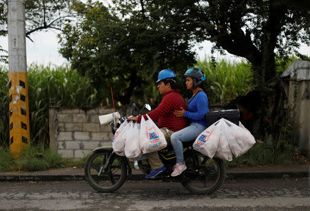 People ride on a motorcycle with bags of aid they received at a distribution center, after an earthquake, in Jojutla de Juarez, Mexico September 21, 2017. REUTERS/Edgard Garrido