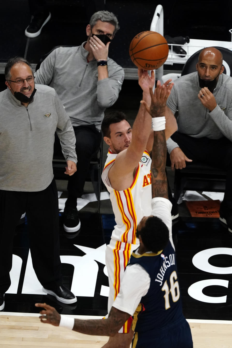 New Orleans Pelicans coaches watch Atlanta Hawks forward Danilo Gallinari (8) shoot as New Orleans Pelicans forward James Johnson (16) defends in the second half of an NBA basketball game Tuesday, April 6, 2021, in Atlanta. (AP Photo/John Bazemore)