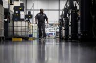 FILE PHOTO: A factory worker walks past a row of automated five-axis cells used in the production and manufacturing of aircraft parts, at Abipa Canada, in Boisbriand