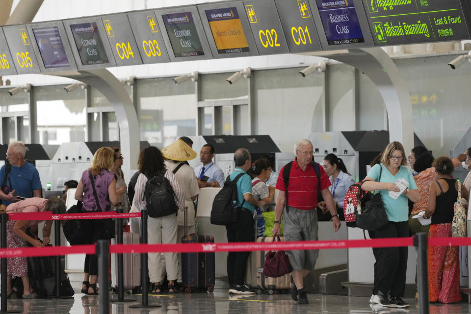 Tourists line up for check-in before departure at International Airport in Siem Reap province, Cambodia as it opened Thursday, Nov. 16, 2023. The new airport can handle 7 million passengers a year, with plans to augment it to handle 12 million passengers annually from 2040. It was constructed under a 55-year build-operate-transfer (BOT) program between Cambodia and China. (AP Photo/Heng Sinith)