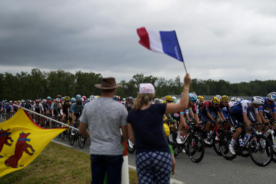 ARCHIVO - Los espectadores saludan el paso del pelotón del Tour de Francia durante la 19na etapa, el viernes 22 de julio de 2022. (AP Foto/Thibault Camus)