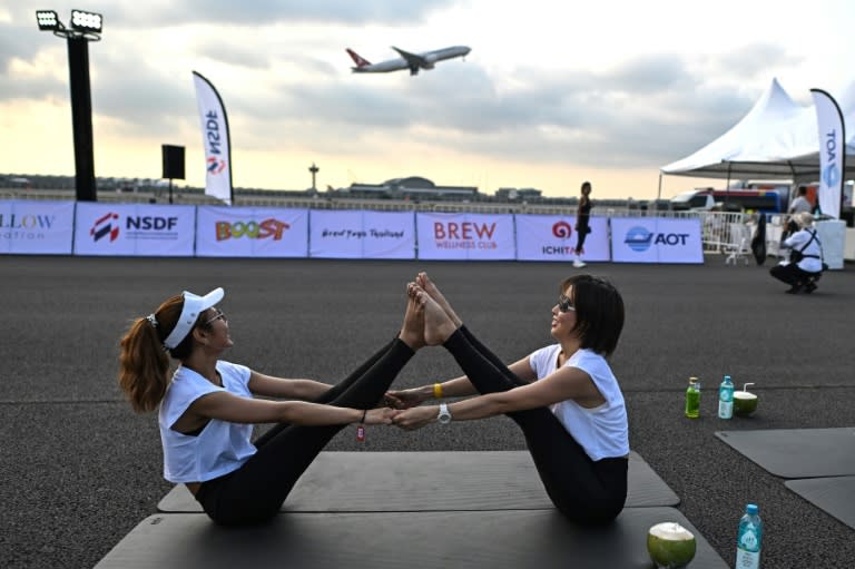 A sunrise "Brew Yoga" event on a runway at Bangkok's international airport on April 27, 2024 (MANAN VATSYAYANA)