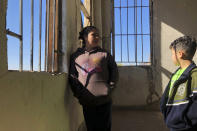 In this Jan. 11, 2020, photo, Enma Floriana chats with her 13-year-old son in the stairway of a migrant shelter in Mexicali, Mexico. The Guatemalan family is seeking asylum in a San Diego immigration court. Illegal border crossings have plummeted as the Trump administration has extended a policy to make asylum seekers wait in Mexico for court hearings in the U.S. (AP Photo/Elliot Spagat)