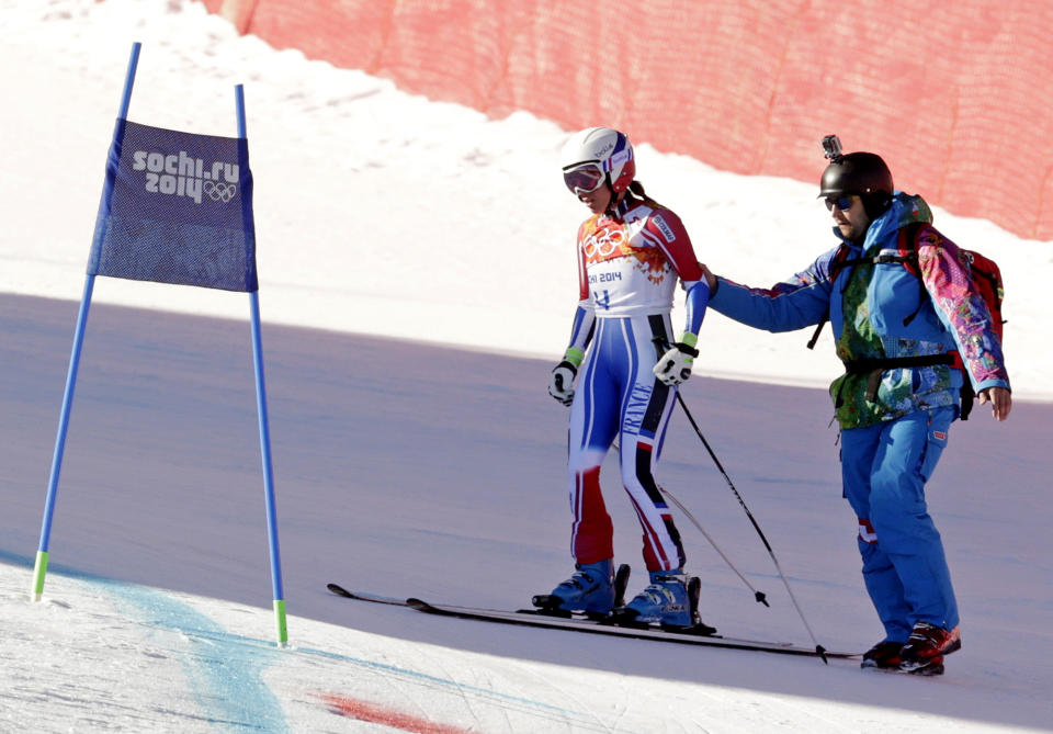 France's Marie Marchand-Arvier is helped after crashing into safety netting during the women's downhill at the Sochi 2014 Winter Olympics, Wednesday, Feb. 12, 2014, in Krasnaya Polyana, Russia. (AP Photo/Charles Krupa)