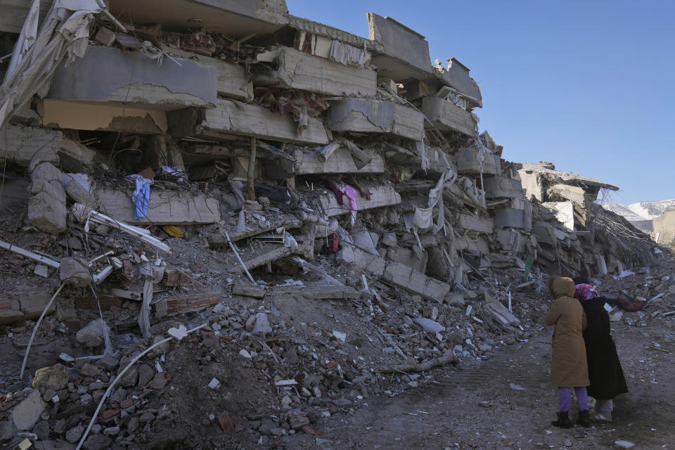 Dos mujeres observan su edificio destruido por un fuerte sismo en Kahramanmaras, en el sur de Turquía, el miércoles 8 de febrero de 2023. (Foto AP/Hussein Malla)