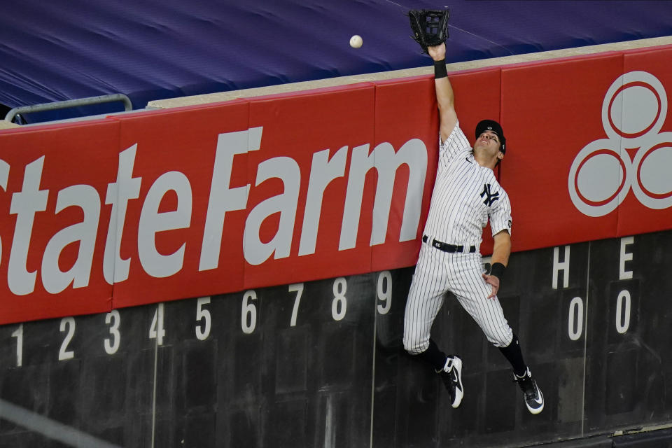 New York Yankees' Mike Tauchman (39) can't make the catch at the wall on a solo home run hit by Boston Red Sox's Xander Bogaerts during the third inning of a baseball game Saturday, Aug. 15, 2020, in New York. (AP Photo/Frank Franklin II)