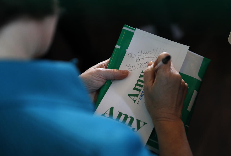 Democratic presidential candidate Sen. Amy Klobuchar, D-Minn., writes a note to an attendee during a campaign event at Crawford Brew Works, Saturday, Feb. 1, 2020, in Bettendorf, Iowa. (AP Photo/John Locher)