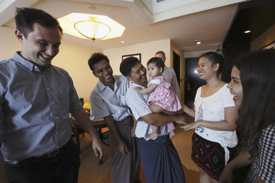 Reuters reporters Wa Lone, center, and Kyaw Soe Oo, second left, celebrate with their family members after being freed from prison, in Yangon, Myanmar, Tuesday, May 7, 2019. Two Reuters journalists who were imprisoned for breaking Myanmar's Official Secrets Act over reporting on security forces' abuses of Rohingya Muslims were pardoned and released Tuesday, the prison chief and witnesses said. (Ann Wang/Pool Photo via AP)