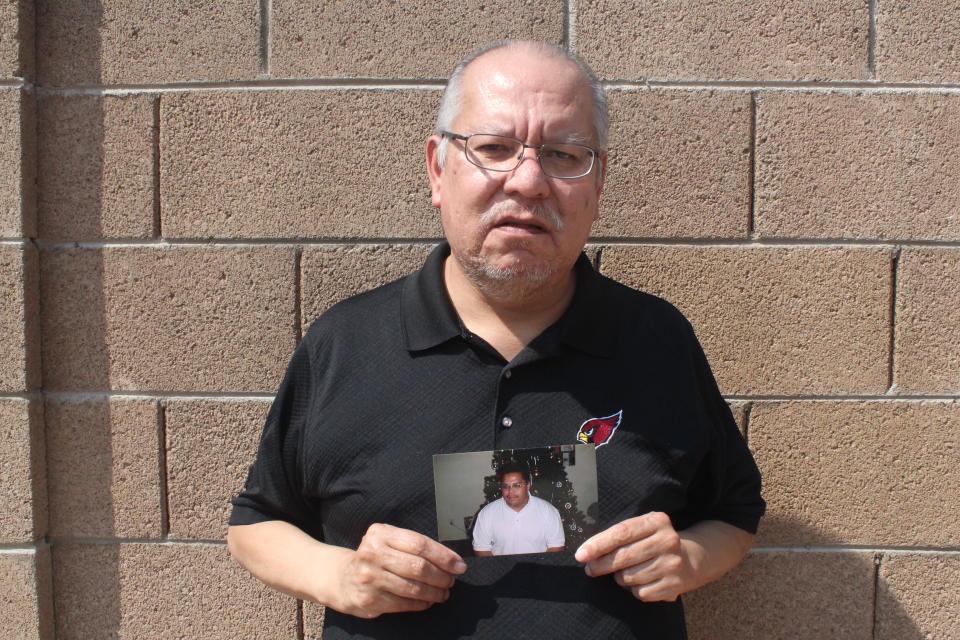 Auska Mitchell holds a photograph of his nephew, Lezmond Mitchell, on Friday, Aug. 21, 2020 in Goodyear, Ariz. Lezmond Mitchell is scheduled to be executed Wednesday, Aug. 26, and the Navajo government is pushing to spare his life on the basis of cultural beliefs and sovereignty. (AP Photo/Jonathan J. Cooper)