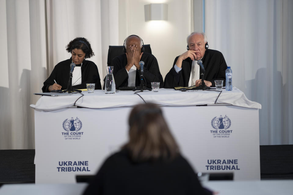 Judges Priya Pillai, left, Zak Yacoob, center, and Stephen Rapp, right, listen to the first witness of the 'people's tribunal' where prosecutors symbolically put Russian President Vladimir Putin on trial for the crime of aggression in Ukraine, in The Hague, Netherlands, Monday, Feb. 20, 2023. (AP Photo/Peter Dejong)