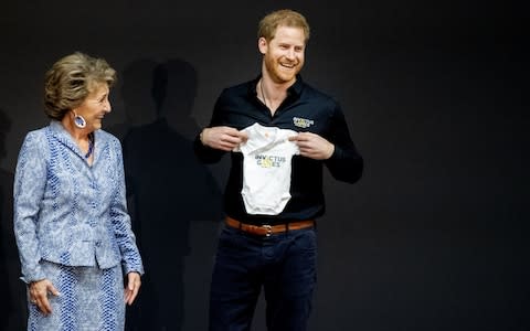 Prince Harry, Duke of Sussex is presented with an Invictus Games baby grow by Princess Margriet of The Netherlands during the launch of the Invictus Games - Credit: &nbsp;Patrick van Katwijk