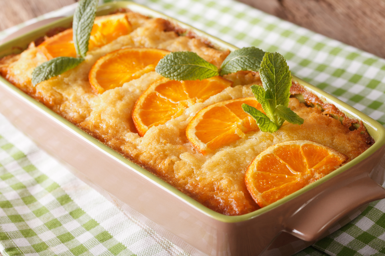 Greek orange phyllo cake, Portokalopita, in a rectangular lime-green lined beige porcelain dish, selective focus, on a lime-green checkered napkin, on a wooden table