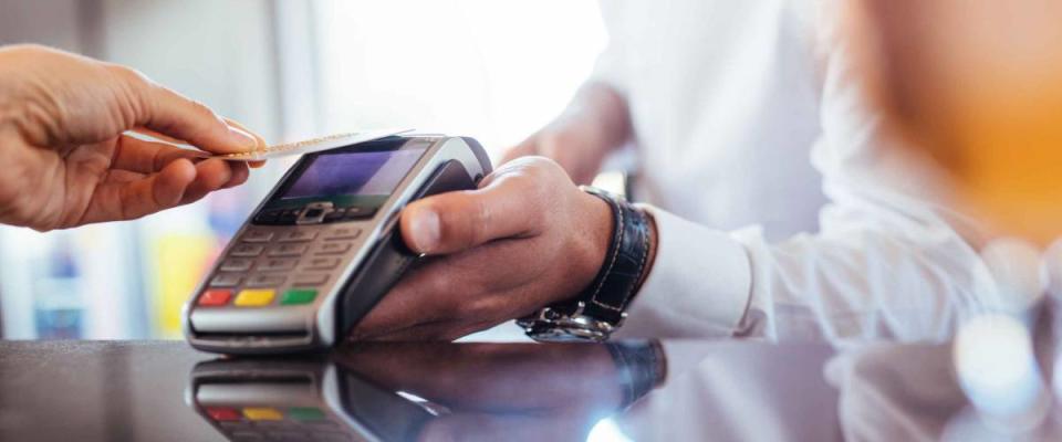 Hand of customer paying with contactless credit card