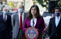 FILE - In this Oct. 15, 2020, file photo, Colorado Secretary of State Jena Griswold, front, speaks as, from back left, Aurora, Colo., Mayor Mike Coffman, Colorado Gov. Jared Polis, and Denver Clerk and Recorder Paul Lopez look on during a news conference about the state's efforts to protect the process of casting a vote in the upcoming general election in downtown Denver. Colorado Gov. Jared Polis is quarantining himself after learning that Aurora Mayor Mike Coffman tested positive for the coronavirus. Coffman's diagnosis on Sunday, Oct. 25, 2020, came over a week after he and the governor appeared with other officials at a news conference. A Polis spokesperson said the governor would quarantine while waiting to hear from contact tracers. Coffman said he worked from home starting Thursday after not feeling well and his symptoms were gone by Saturday. He says he got a rapid test Sunday in hopes of being cleared to return to his office and schedule but will now quarantine at home. (AP Photo/David Zalubowski, File)