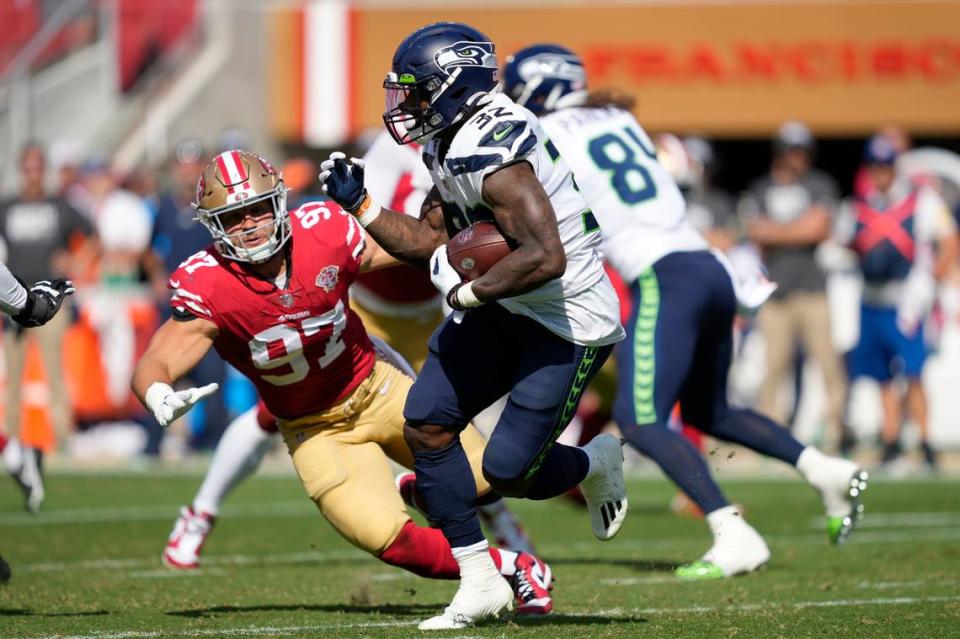 Seattle Seahawks running back Chris Carson (32) runs against San Francisco 49ers defensive end Nick Bosa (97) during the second half of an NFL football game in Santa Clara, Calif., Sunday, Oct. 3, 2021. (AP Photo/Tony Avelar)