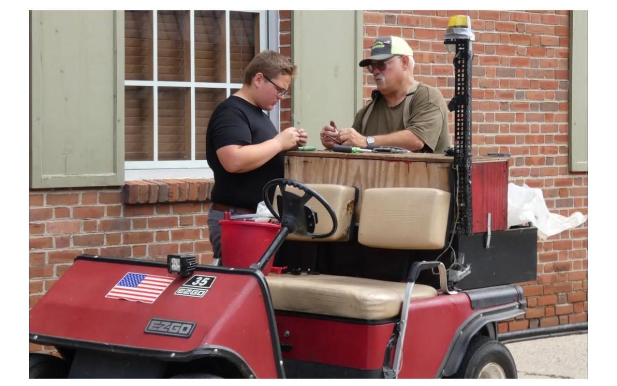 Jim Rinker and his grandson Isaac Beck prepare to wire electrical cable needed for Bratwurst Festival vendors in 2021.