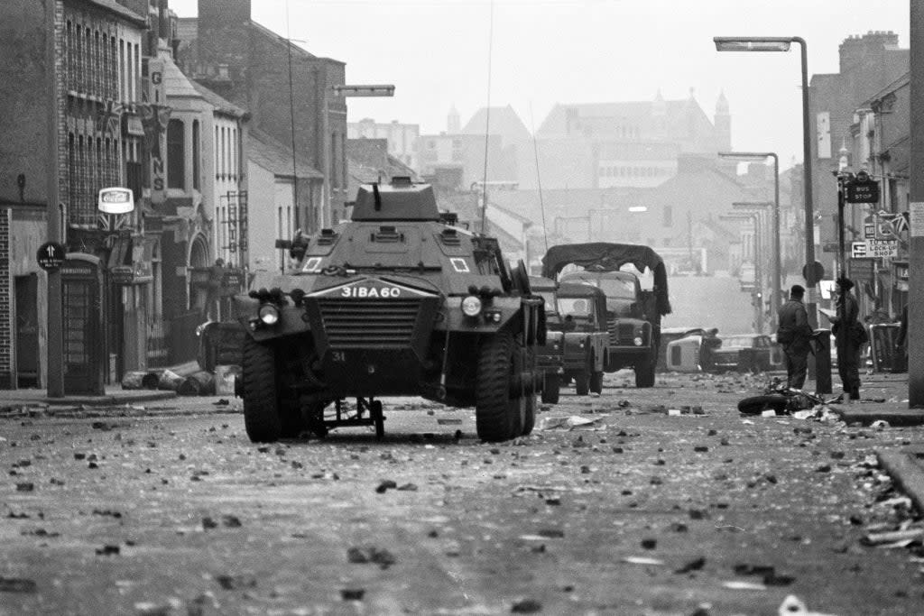 Armoured cars rumble over the rubble past overturned cars and a wrecked motor cycle at dawn in Belfast’s Protestant Shankill Road, after a night of violence in which three people died. (PA Archive)