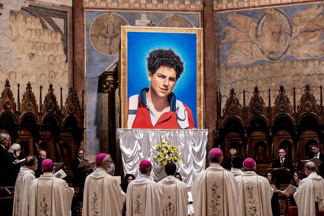 <p>Vatican Pool/Getty Images</p> A tapestry featuring a portrait of Carlo Acutis hangs at the St. Francis Basilica during his beatification ceremony on October 10, 2020 in Assisi, Italy.