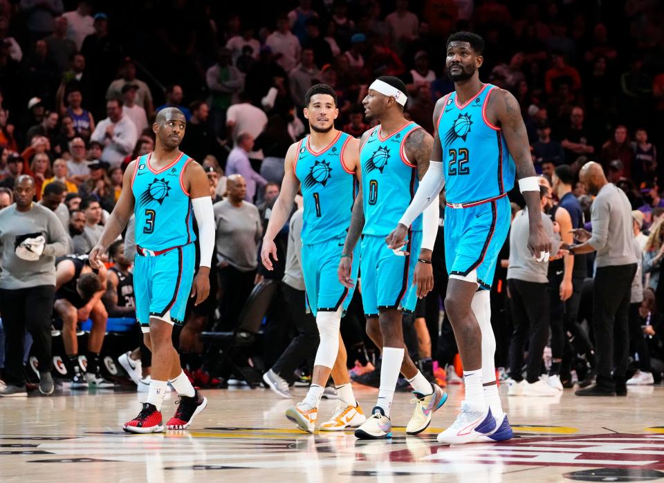 Phoenix Suns guard Chris Paul (3), guard Devin Booker (1), forward Torrey Craig (0), and center Deandre Ayton (22) walk to the bench after the Orlando Magic called a time-out in the second half at Footprint Center in Phoenix on March 16, 2023.