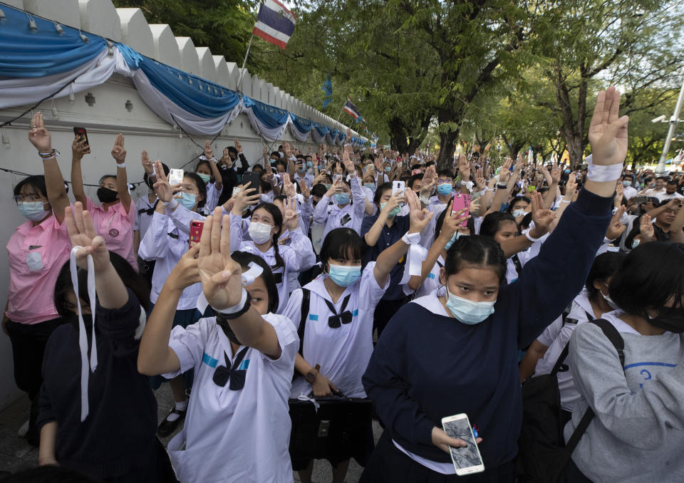 Pro-democracy students raise a three-fingers, symbol of resistance salute during a protest rally in front of Education Ministry in Bangkok, Thailand, Wednesday, Aug. 19, 2020. Student protesters have stepped up pressure on the government with three core demands: holding new elections, amending the constitution and ending the intimidation of critics of the government. (AP Photo/Sakchai Lalit)