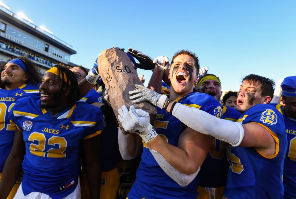 South Dakota State's Tucker Kraft yells as he grabs the Dakota Marker trophy after the team's win in the annual game against North Dakota State on Saturday, November 6, 2021 at Dana J. Dykhouse Stadium in Brookings.