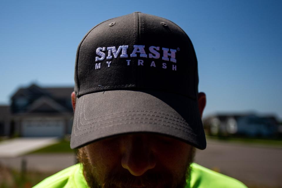 Truck operator Brandon Swanstrom poses wearing a Smash My Trash hat while working near a construction site on Tuesday, June 21. The company looks to save customers money while offering greener waste removal.