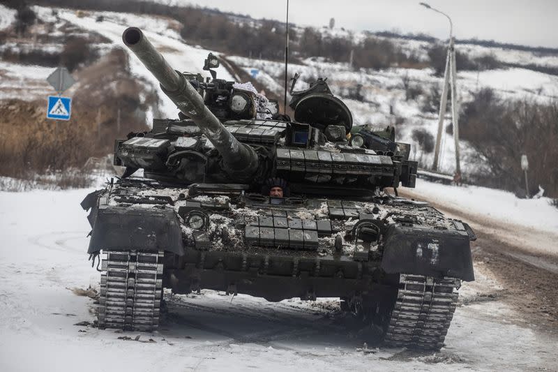 Ukrainian serviceman drives a tank along a road outside the frontline town of Bakhmut