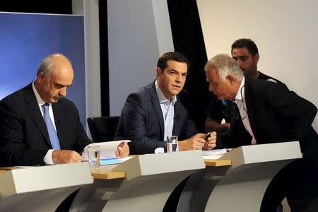 Greece's former prime minister and leader of leftist Syriza party Alexis Tsipras (C) and leader of conservative New Democracy party Evangelos Meimarakis (L) prepare for a political leaders' debate at the headquarters of state broadcaster ERT, in Athens, Greece, September 9, 2015. REUTERS/Michalis Karagiannis