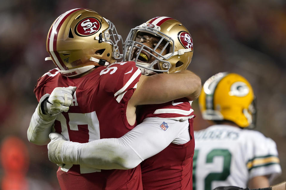 San Francisco 49ers defensive end Arik Armstead, center, is congratulated by defensive end Nick Bosa, left, after sacking Green Bay Packers quarterback Aaron Rodgers (12) during the first half of an NFL football game in Santa Clara, Calif., Sunday, Nov. 24, 2019. (AP Photo/Tony Avelar)