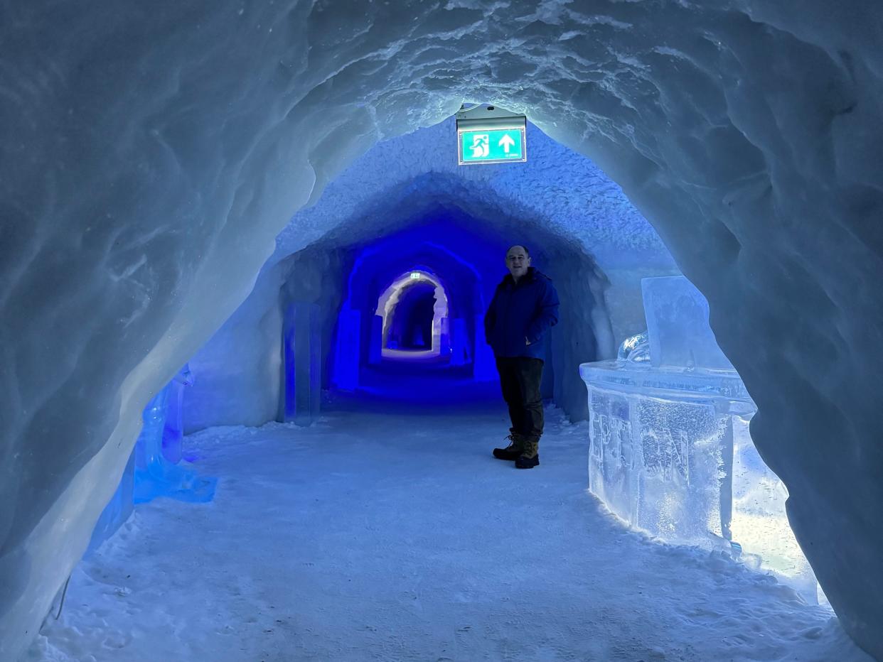 Man standing below exit sign in snow hotel in Norway