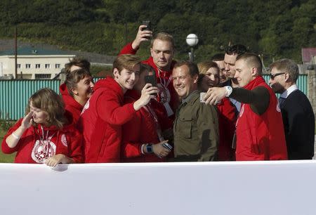 Russia's Prime Minister Dmitry Medvedev (2nd R, front) poses for a picture with participants of the all-Russian youth educational forum "Iturup" in Kurilsk during his visit to Iturup Island, one of four islands known as the Southern Kurils in Russia and the Northern Territories in Japan, August 22, 2015. REUTERS/Dmitry Astakhov/RIA Novosti/Pool