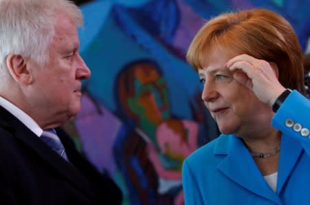 FILE PHOTO: German Chancellor Angela Merkel talks to Interior Minister Horst Seehofer in Berlin, Germany, June 13, 2018. REUTERS/Michele Tantussi/File Photo