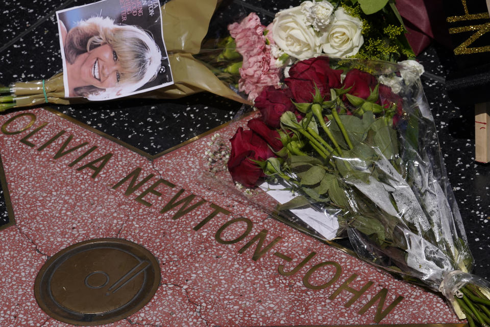 Flowers adorn Olivia Newton-John's Hollywood Walk of Fame star in Los Angeles, Monday, Aug. 8, 2022. Newton-John, the Grammy-winning superstar who reigned on pop, country, adult contemporary and dance charts with such hits as "Physical" and "You're the One That I Want" has died. She was 73. (AP Photo/Damian Dovarganes)