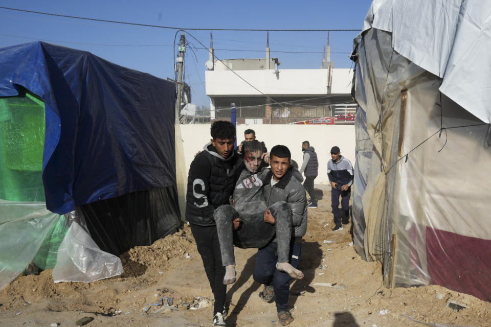 Palestinians evacuate wounded after an Israeli strike hit a building next to the Al-Aqsa Hospital in Deir al Balah, Gaza Strip, on Wednesday, Jan 10, 2023. (AP Photo/Adel Hana)