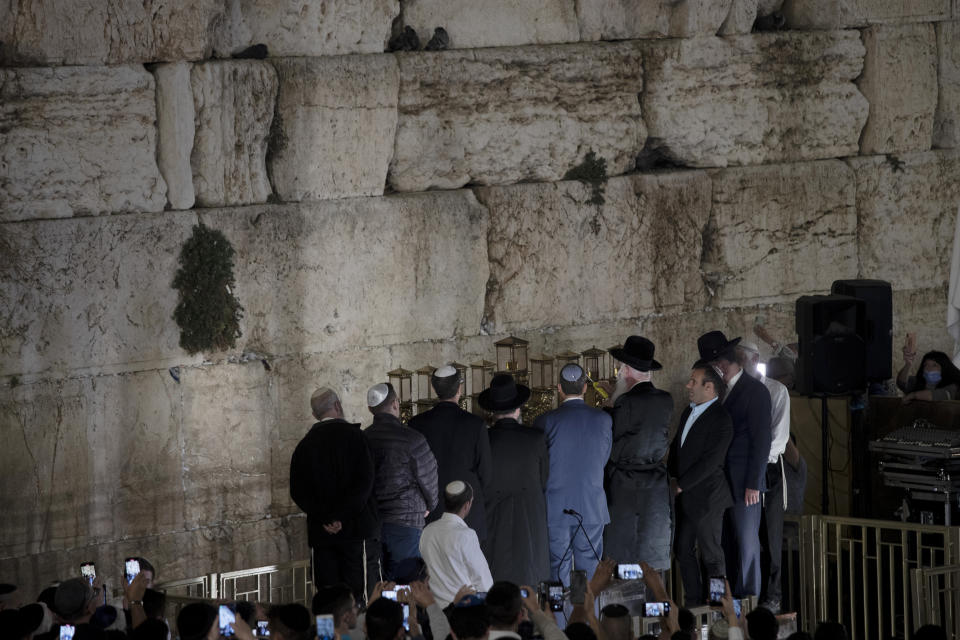 Dignitaries and religious leaders light the menorah on the third night of Hanukkah at the Western Wall, in the Old City of Jerusalem, Tuesday, Nov. 30, 2021. Holocaust survivors marked the third night of Hanukkah on Tuesday with a menorah-lighting ceremony at Jerusalem's Western Wall that paid tribute to them and the 6 million other Jews who were killed by the Nazis. (AP Photo/Maya Alleruzzo)