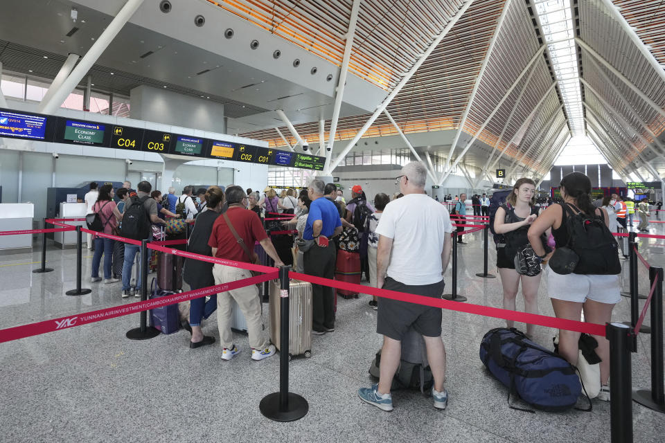 Tourists line up for check-in before departure at International Airport in Siem Reap province, Cambodia as it opened Thursday, Nov. 16, 2023. The new airport can handle 7 million passengers a year, with plans to augment it to handle 12 million passengers annually from 2040. It was constructed under a 55-year build-operate-transfer (BOT) program between Cambodia and China. (AP Photo/Heng Sinith)