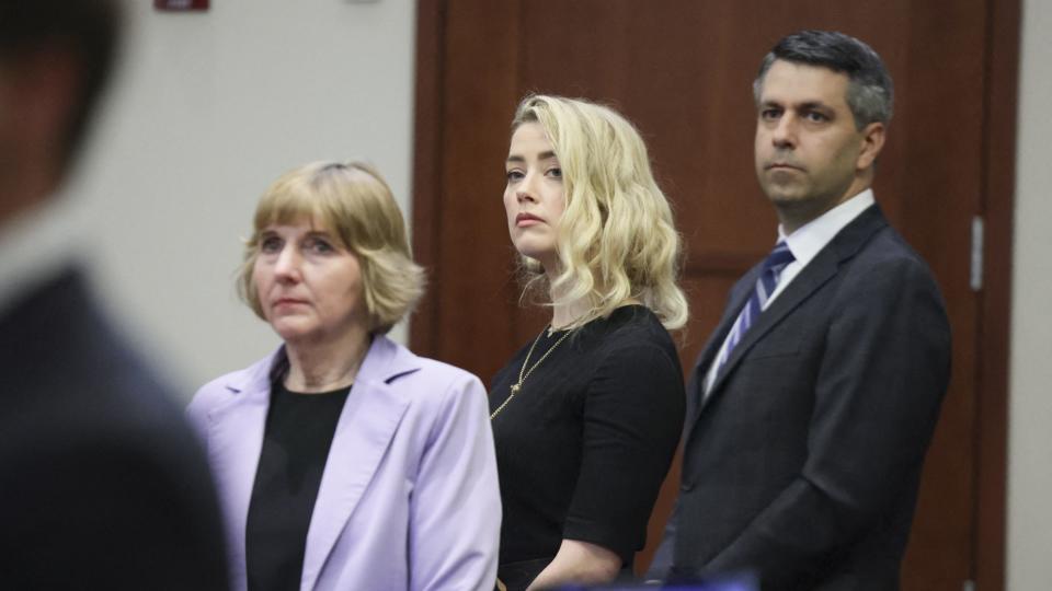 Amber Heard stands with her lawyers Elaine Bredehoft and Benjamin Rottenborn before the jury said that they believe she defamed ex-husband Johnny Depp while announcing split verdicts in favor of both her ex-husband Johnny Depp and Heard on their claim and counter-claim in the Depp v. Heard civil defamation trial at the Fairfax County Circuit Courthouse