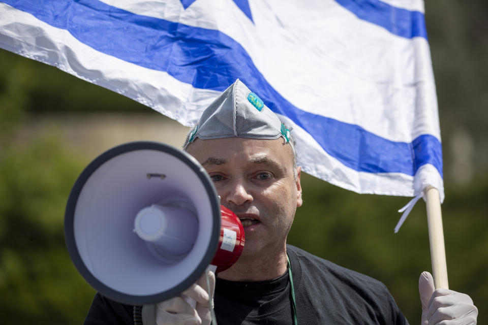 An Israeli supporter of Prime Minister Benjamin Netanyahu protests in front Israel's Supreme Court, in Jerusalem, Tuesday, March 24, 2020. Israel appeared on the verge of a constitutional crisis Tuesday as top members of Benjamin Netanyahu's Likud urged their party colleague and parliament speaker to defy a Supreme Court order to hold an election for the prime minister's successor. (AP Photo/Ariel Schalit)