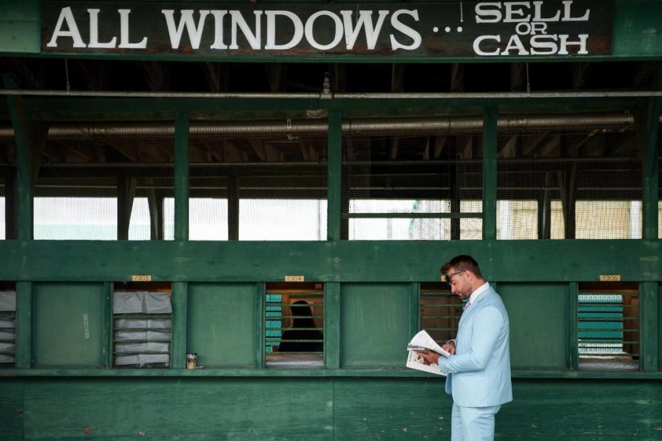 A spectator plans his wager on the day of the 148th Kentucky Derby at Churchill Downs in Louisville, Ky., Saturday, May 6, 2022.