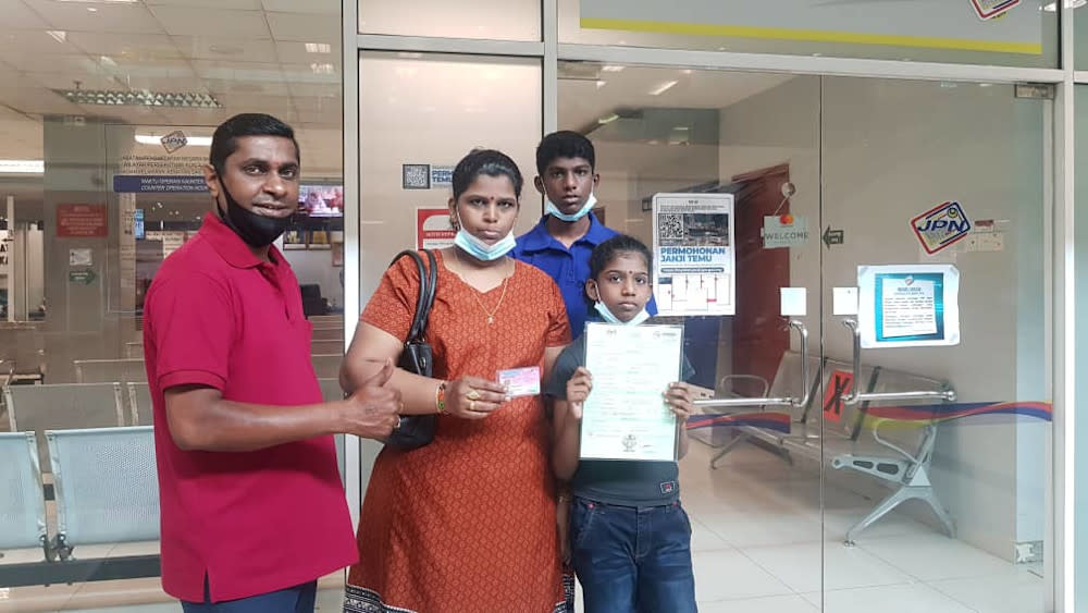 Karthiyani Ragunathan, 10, received her birth certificate and her MyKID (an identity card for Malaysian children aged below 12) on August 5, 2020. Seen here are her mother, her brother and activist Shanmugam Narayanasamy who assisted in their case. — Picture courtesy of Shanmugam Narayanasamy