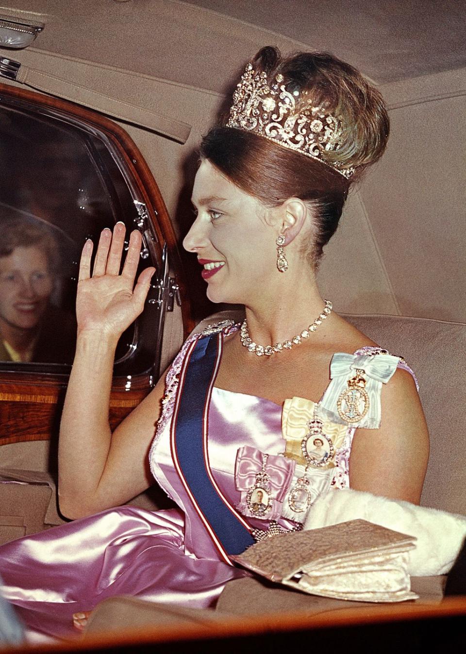 <p>Princess Margaret wearing the Poltimore Tiara (and a perfectly coordinated hairdo) drives into Buckingham Palace for a state banquet 1962. </p>