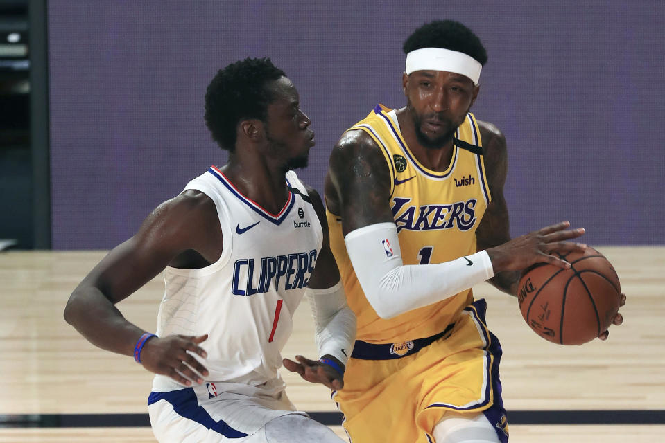 Los Angeles Lakers Kentavious Caldwell-Pope, right, collides with Los Angeles Clippers Reggie Jackson, left, during an NBA basketball game Thursday, July 30, 2020, in Lake Buena Vista, Fla. (Mike Ehrmann/Pool Photo via AP)