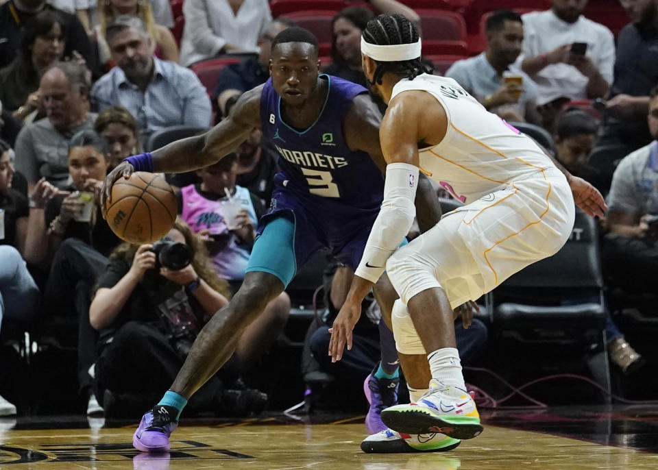 Charlotte Hornets guard Terry Rozier (3) attempts to dribble around Miami Heat guard Gabe Vincent (2) during the first half of an NBA basketball game Thursday, Nov. 10, 2022, in Miami. (AP Photo/Marta Lavandier)