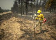 Firefighter Vadix Armendarez looks for hot spots along State Highway 434 north of Mora after a late night on the line as firefighters from all over the country converge on Northern New Mexico to battle the Hermit's Peak and Calf Canyon fires on May 13, 2022. (Jim Weber/Santa Fe New Mexican via AP)