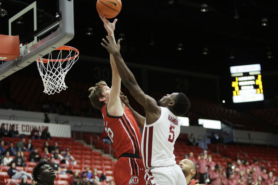 Utah center Branden Carlson, left, blocks a shot by Washington State guard TJ Bamba during the second half of an NCAA college basketball game, Sunday, Dec. 4, 2022, in Pullman, Wash. Utah won 67-65. (AP Photo/Young Kwak)