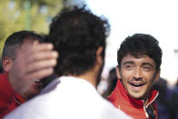 Ferrari driver Charles Leclerc, right, of Monaco reacts as he meets Daniel Ricciardo of Australia driver of RB, the team previously known as AlphaTauri as they sign autographs ahead of the first practice session of the Australian Formula One Grand Prix at Albert Park, in Melbourne, Australia, Friday, March 22, 2024. (AP Photo/Scott Barbour)