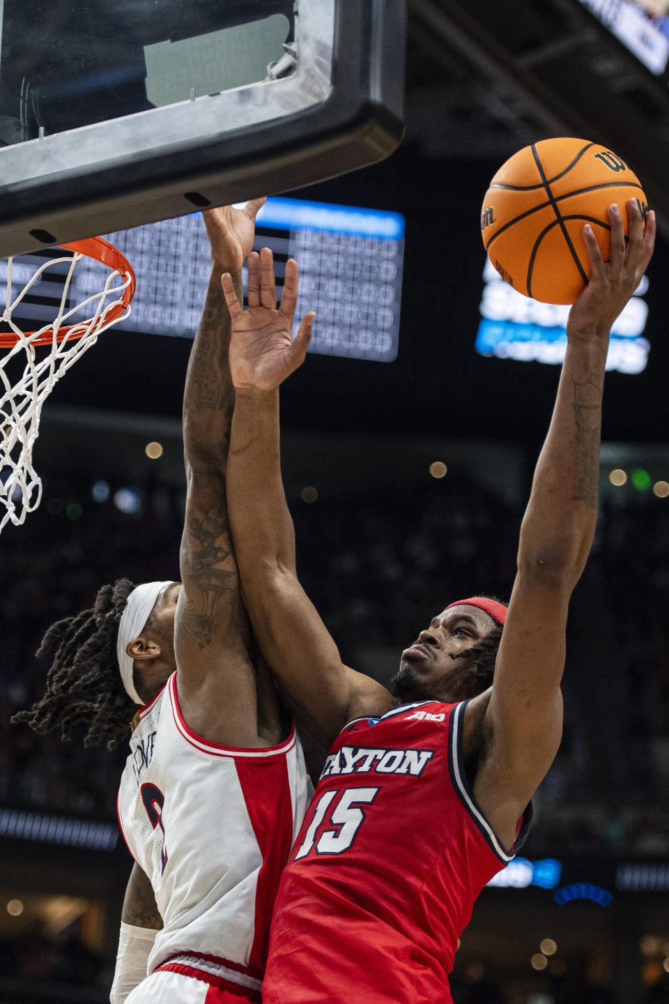 Dayton forward DaRon Holmes II (15) lays the ball up while guarded by Arizona guard Caleb Love, left, during the second half of a second-round college basketball game in the NCAA Tournament in Salt Lake City, Saturday, March 23, 2024. (AP Photo/Isaac Hale)