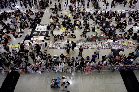 Anti-Extradition bill protesters distribute leaflets to passengers during a mass demonstration at the Hong Kong international airport, in Hong Kong