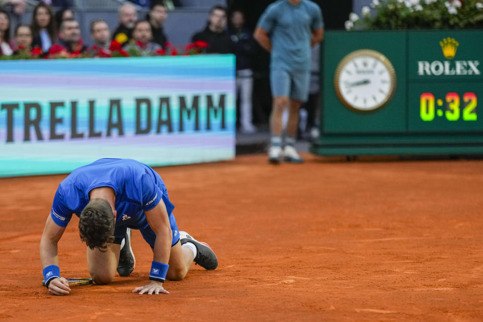 Jiri Lehecka, of the Czech Republic, lies on the ground before retiring during a semi-final match against Felix Auger-Aliassime, of Canada, at the Mutua Madrid Open tennis tournament in Madrid, Spain, Friday, May 3, 2024. (AP Photo/Bernat Armangue)